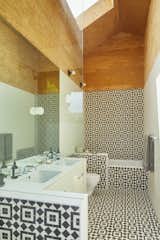 Upstairs is a show-stopping oversize bathroom. “When I chose the tile, I was afraid I was going to get sick of it,” says homeowner Melina Polly, “but I do love it. It makes me happy every time I walk in there.” The tiles are Fez by Granada Tile, the sinks are from Kohler, and the faucets are from Newport Brass.