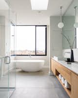 The en suite bathroom features a soaking tub and large windows overlooking the marshy waters.