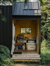The semi-enclosed kitchen has a barbecue and a two-burner propane stove from Coleman. The Gersby bookcase, kitchen cabinets and countertop are also from Ikea while the drop cloth is from Chicago Canvas and Supplies.