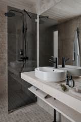 The bathrooms are outfitted with grey tile that features a stone-like appearance that references the outdoors.