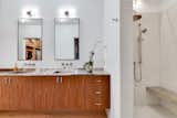 The home features four-and-a-half baths. This one with two sinks and an open penny-tile shower area.