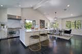 The open chef’s kitchen boasts Carrara marble countertops, Viking appliances, and flows into a light-infused dining area.