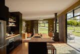Extensive glazing keeps the open-plan living space bright and airy and provides expansive views, allowing the couple to immerse themselves in their rural surroundings. The hearth is a Horama Fireplace by Chiminees Philippe. 