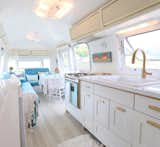 Designer and writer Lynne Knowlton revamped her 1976 Airstream with a girly edge -- without once using any lace or pink. By consistently using brushed gold hardware, tufted blue seating (which even appears to be original!), and casually-thrown fringed blankets, the space is packed with effortless personality. Light-colored wide plank flooring and white paint keep the space light and airy.
