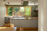 The new kitchen is defined by a 14-foot island and bank of windows overlooking the backyard. The counters are stainless steel and maple butcher block. The ceiling sconces are Cedar & Moss.