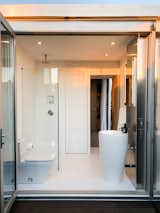 The compact bathroom is outfitted in Designer White Corian surfaces and high-end fixtures.