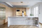 Sculptural plywood walls weave new life into a 19th-century Parisian apartment while preserving its historic Haussmannien features.