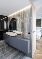 Massive gray onyx-style porcelain tiles give the master bath a luxurious appearance. "The tiles for the bathroom and kitchen were so hard to get to the fifth floor with a tiny elevator," notes the architect. "They were three meters by one-and-a-half meters, and getting them upstairs and cutting them on-site was really complicated."